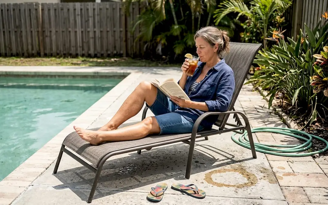 Homeowner relaxing on sunlit Florida pool deck