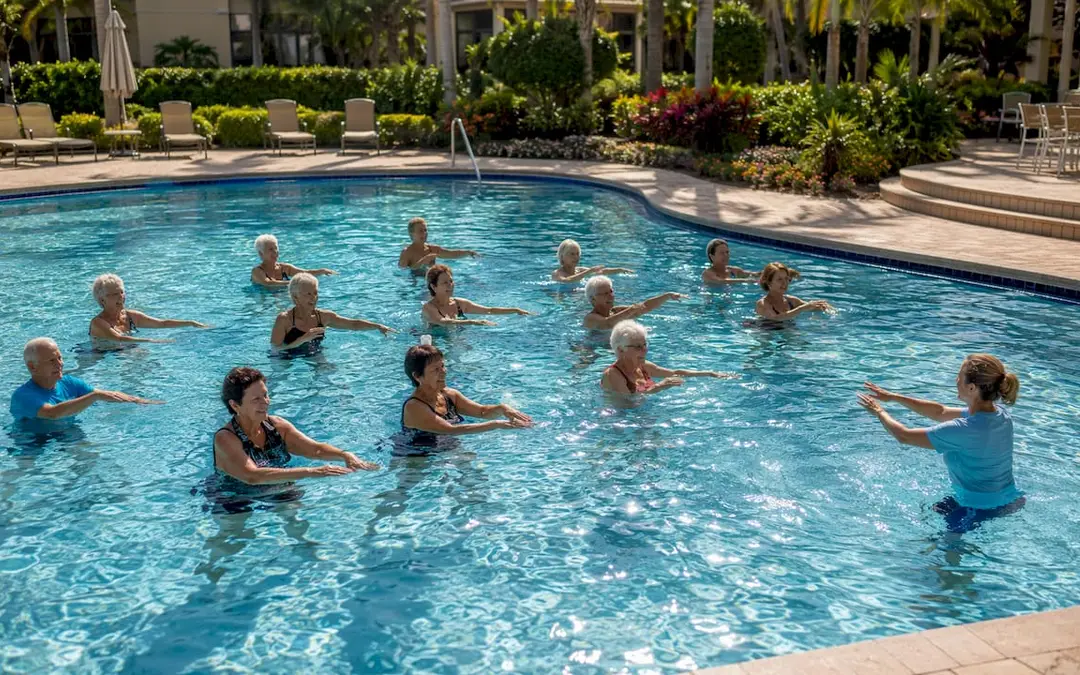 Active adults doing pool exercises outdoors