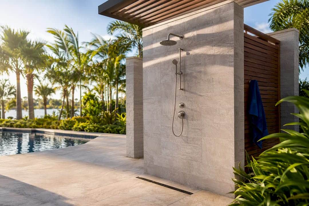 Luxury outdoor shower beside landscaped pool terrace